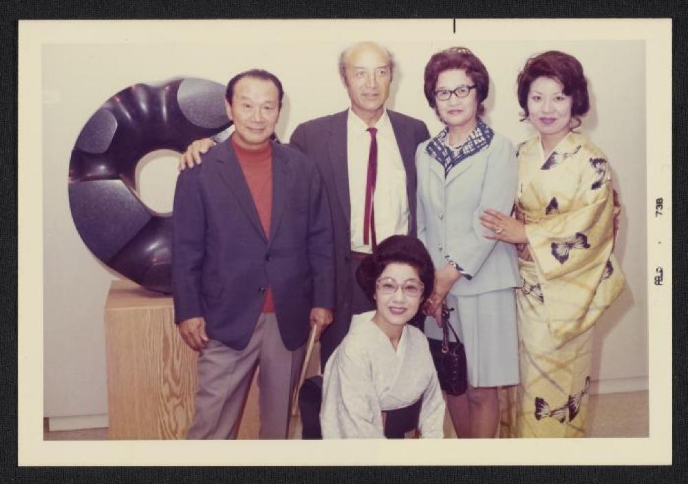 Noguchi with Taro Okamoto and guests in front of Black Sun, exhibition opening, Minami Gallery, 1973