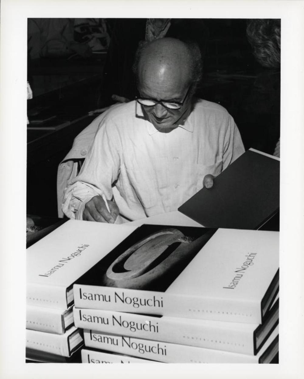 Noguchi signing catalogues at opening reception for "Noguchi's Imaginary Landscapes," Detroit Institute of Fine Arts, April 10 – June 10 1979 (travel from Walker Art Center).